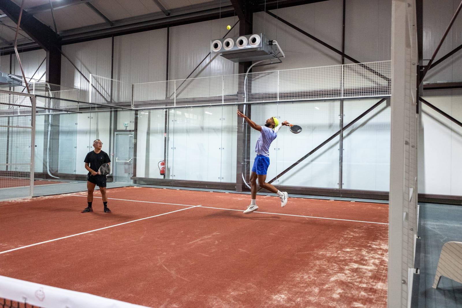 Joueur au service sur un terrain indoor