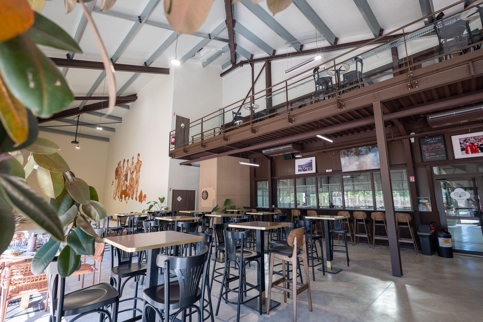 Salle du Club-House avec ses écrans et ses tables